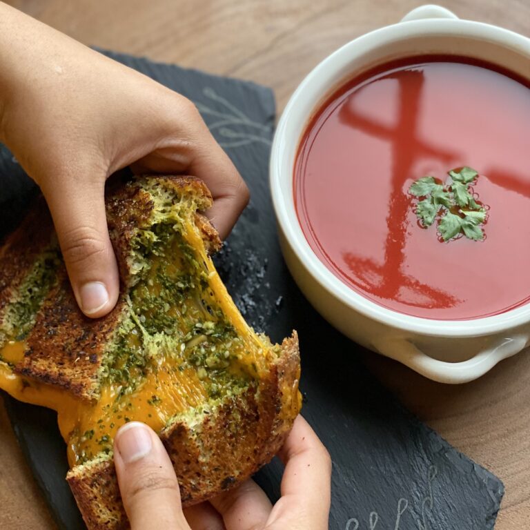 cheese pull of a keto low carb sugar free crispy grilled cheese sandwich with tomato soup