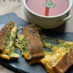 three slices of low carb bread grilled cheese pesto sandwich with soup
